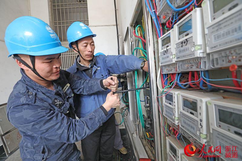 2月15日，国王浙江宁海供电公司员工彭平（左一）和陈红焰（左二）在华庭家园抢修。章勇涛 摄