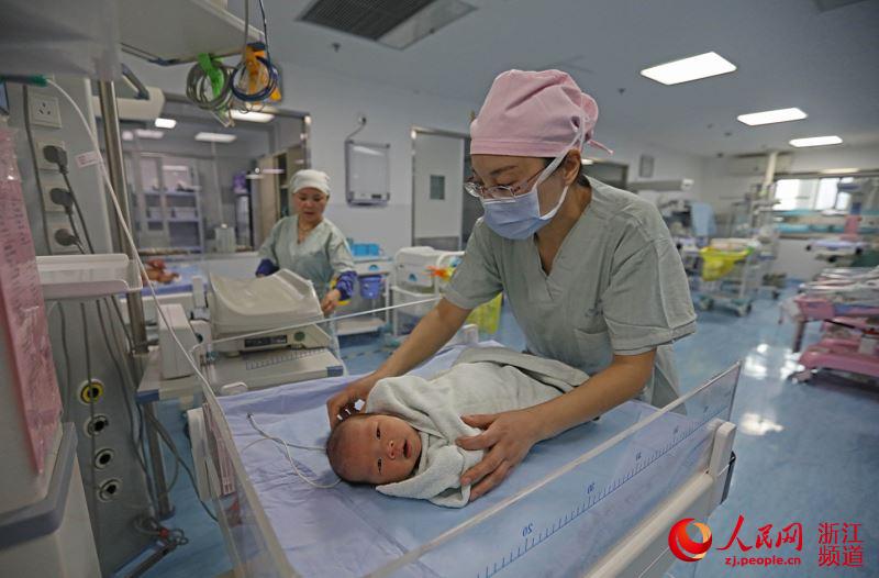 2月15日，护士谢冬燕在宁波市宁海县妇幼保健院的新生儿室里忙碌。章勇涛 摄