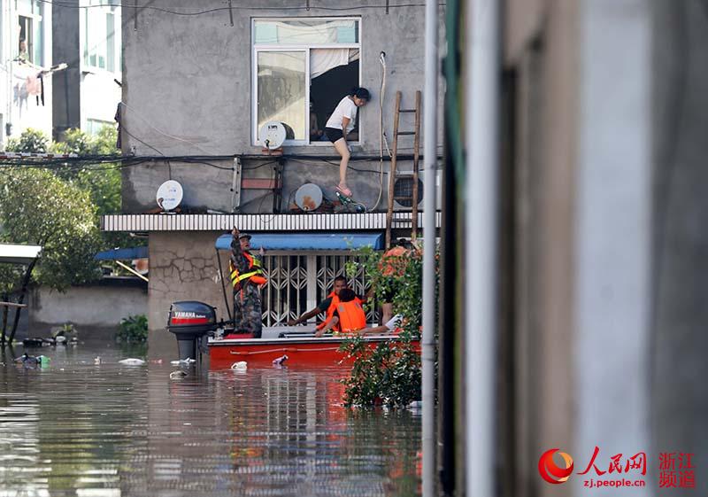8月11日，浙江台州临海一救援队正在转移受灾群众。章勇涛 摄