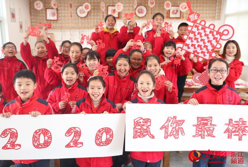 2020年1月7日，浙江湖州市德清縣乾元鎮中心小學學生展示“2020”年字樣的剪紙作品。王正攝