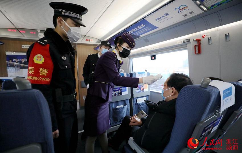 乘警會同列車乘務員為旅客測溫。