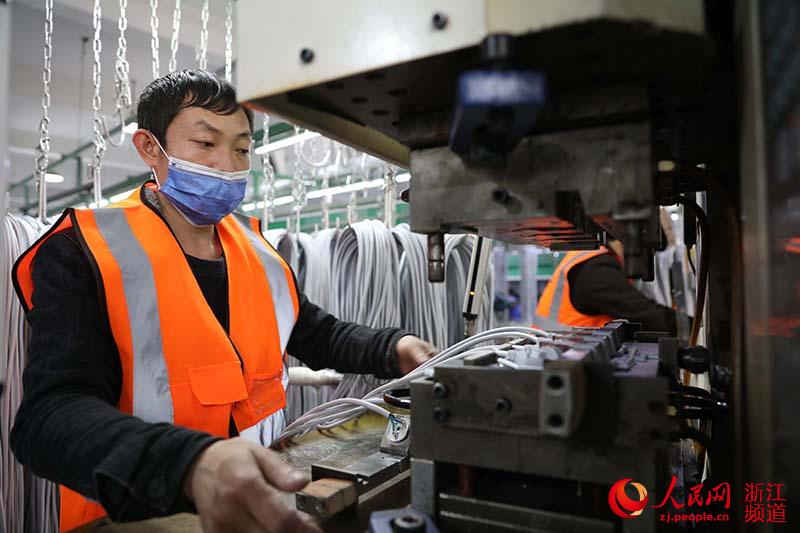 2月28日，在慈溪市萬能電子有限公司，來自貴州黔西南布依族苗族自治州的余成旭在車間裡注塑加工。章勇濤 攝