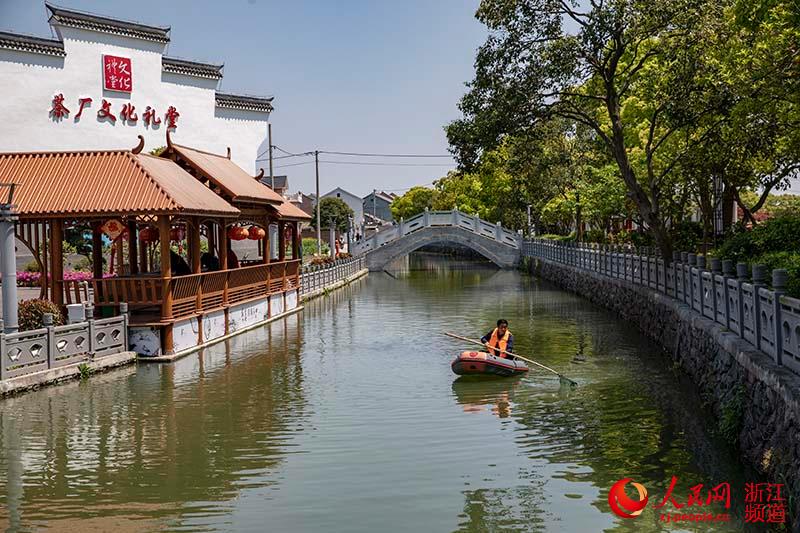 4月29日，河道保潔員在寧波市北侖區梅山街道梅港村生態河埠頭清理漂浮物。章勇濤 攝