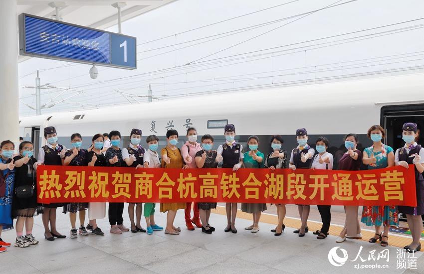 乘坐杭州東至安吉G9398次首發列車的旅客在站台上與乘務人員合影。周圍  攝