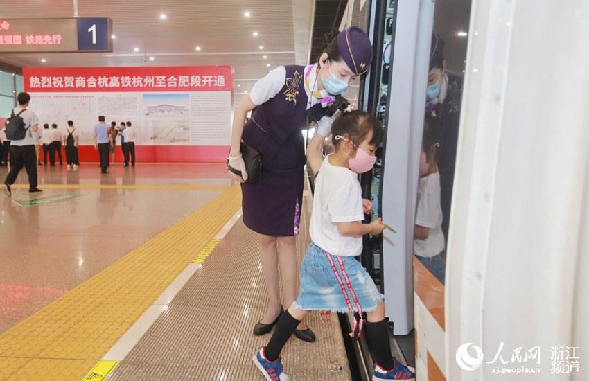 商合杭高鐵合湖段開通運營，杭州東至安吉G9398次列車首發，一名兒童旅客在乘務員的攙扶下上車。周圍  攝