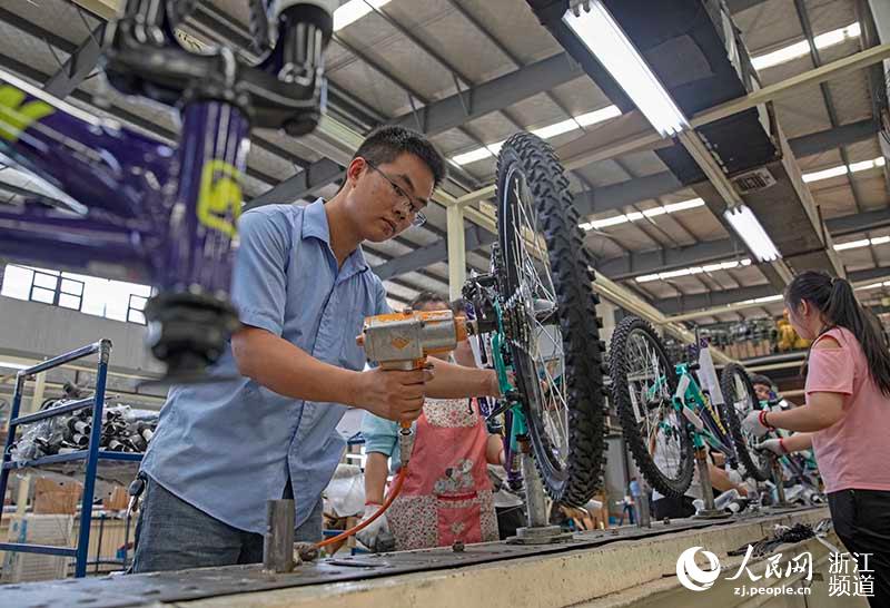 7月14日，在浙江慈溪一家自行车生产企业，工人忙着组装自行车。章勇涛 摄