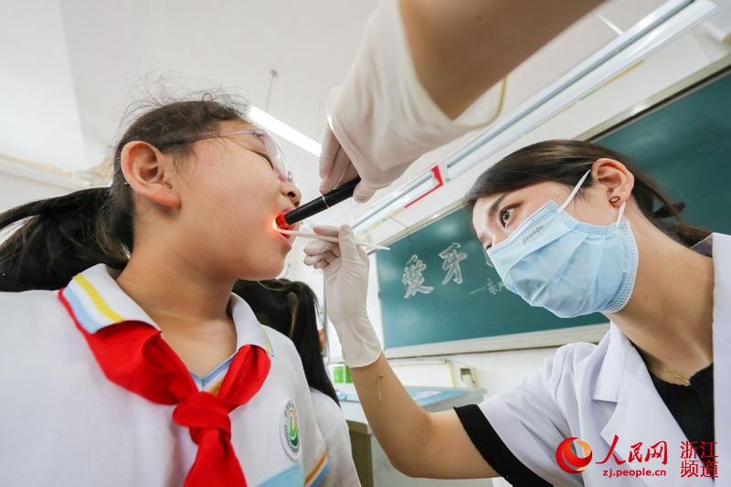 9月17日，在浙江省湖州市德清县武康街道东风小学，牙科医生为学生们进行口腔检查。