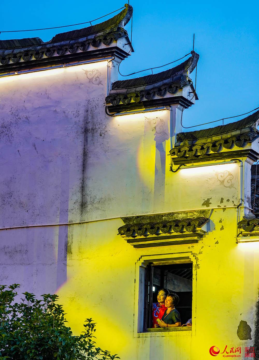 6月24日，在杭州市富陽區龍門古鎮，村民在窗台前觀看慶祝中國共產黨成立100周年大型誦讀活動。人民網 章勇濤攝