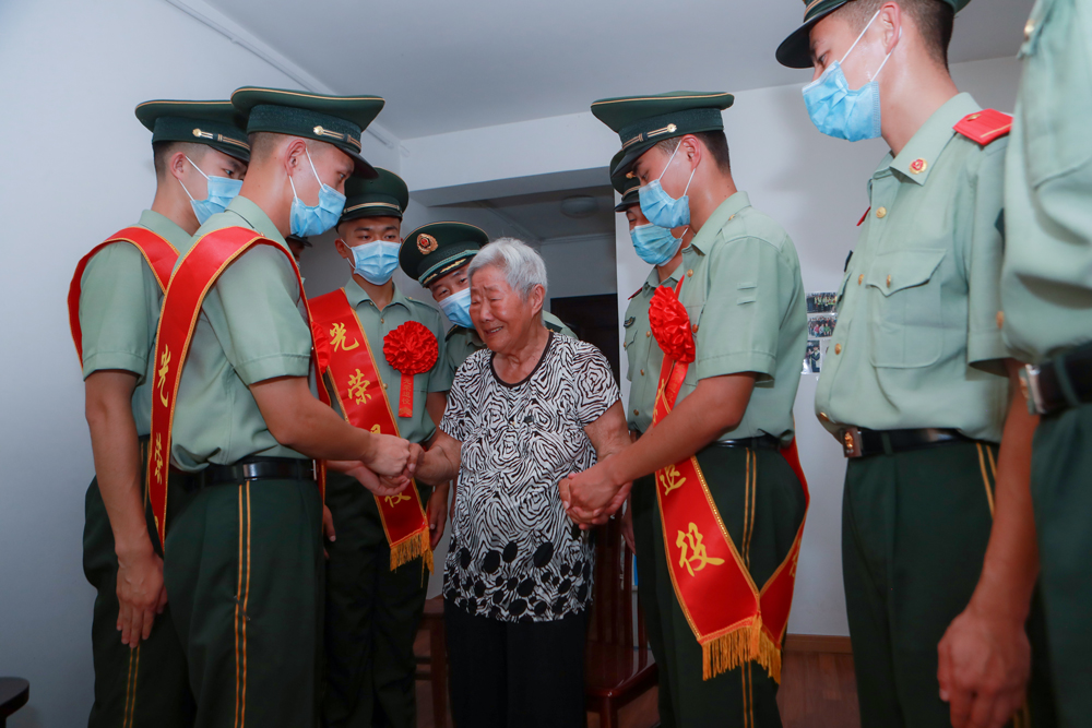 退伍老兵与驻地孤寡老人武玉华奶奶告别，并将照顾老人的任务交到新同志手中。胡港摄