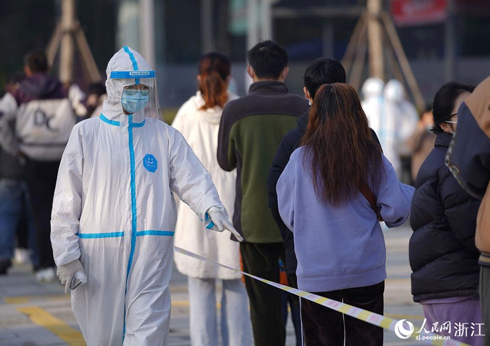 12月9日，医护人员在宁波市镇海区庄市街道一检测点维护秩序。人民网 章勇涛摄