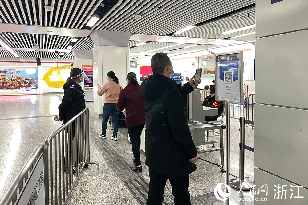 12月8日12时起，杭州地铁启用“场所码”，市民有序扫码进站。人民网 潘怡迪摄