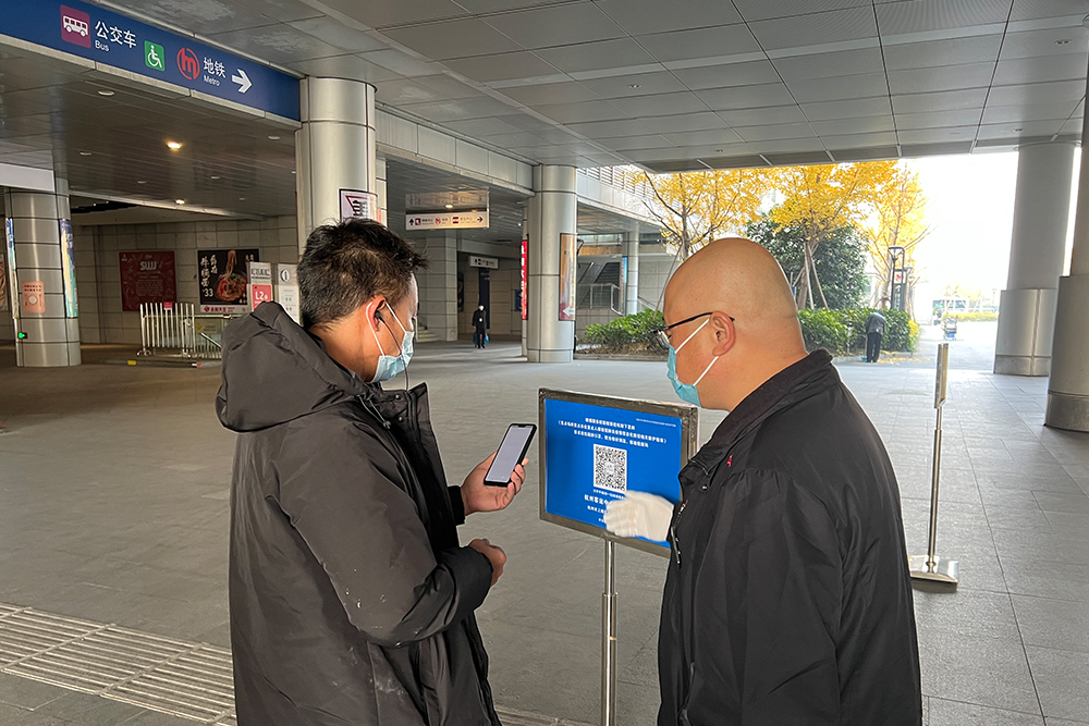 杭州客運中心外，旅客在工作人員引導下掃描“場所碼”。杭州客運中心供圖