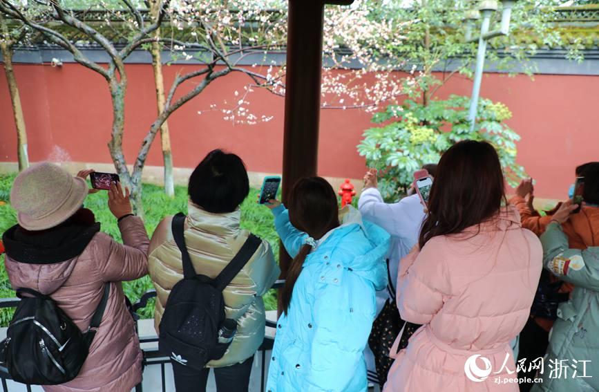 行至红墙前，游客们纷纷拿出手机拍摄。人民网 方彭依梦摄