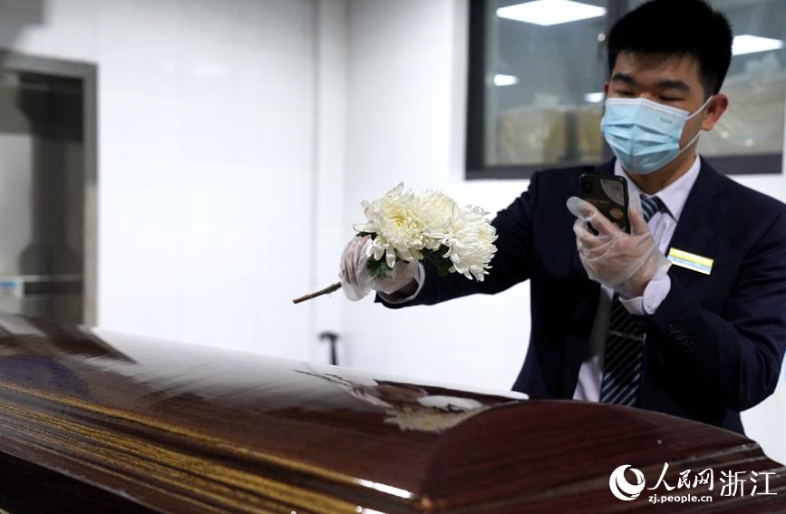 杭州殯儀館代辦工作人員為逝者送上鮮花。人民網 張麗瑋攝