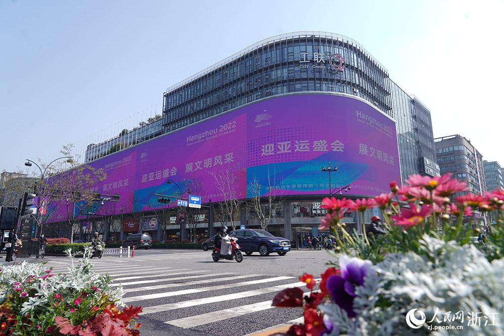 3月29日，杭州湖濱街區戶外屏幕上，數十幅亞運宣傳海報循環播放。人民網 章勇濤攝
