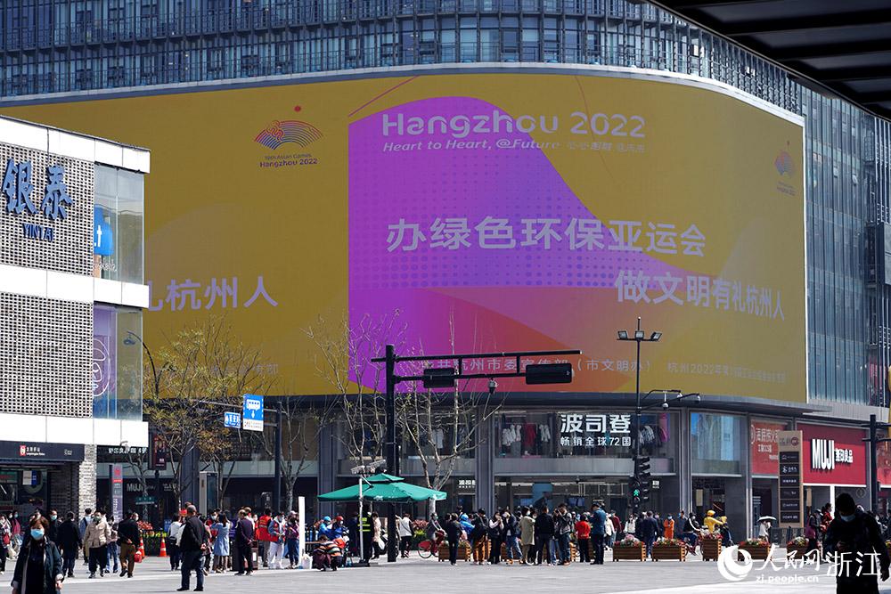 3月29日，杭州湖濱街區戶外屏幕上，數十幅亞運宣傳海報循環播放。人民網 章勇濤攝