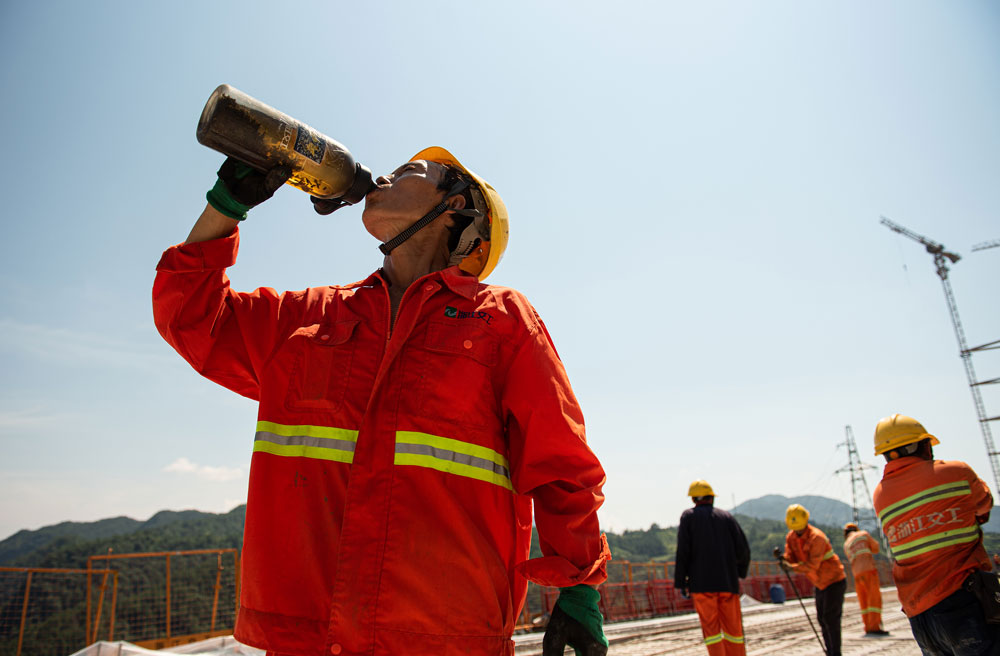 在景文高速控制性工程高岭头水库特大桥施工现场，建设者们顶着烈日，坚守在自己的岗位上。文成县委宣传部供图