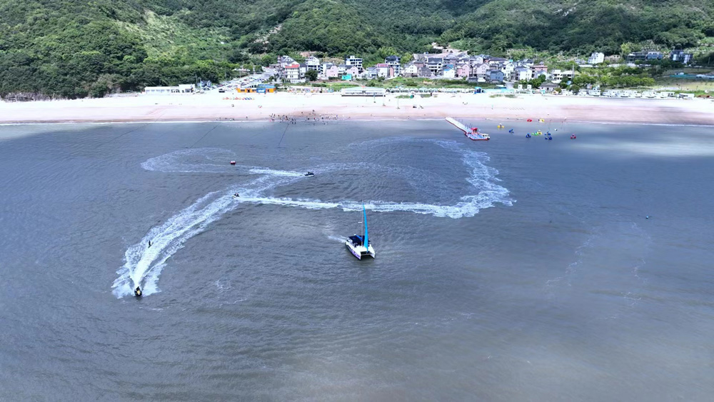 8月5日，在宁波象山东旦时尚运动海滩，不少游客正在体验水上游乐项目。周莹摄