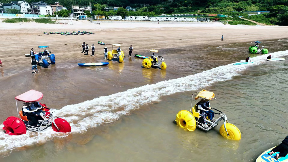 8月5日，在宁波象山东旦时尚运动海滩，不少游客正在体验水上游乐项目。周莹摄