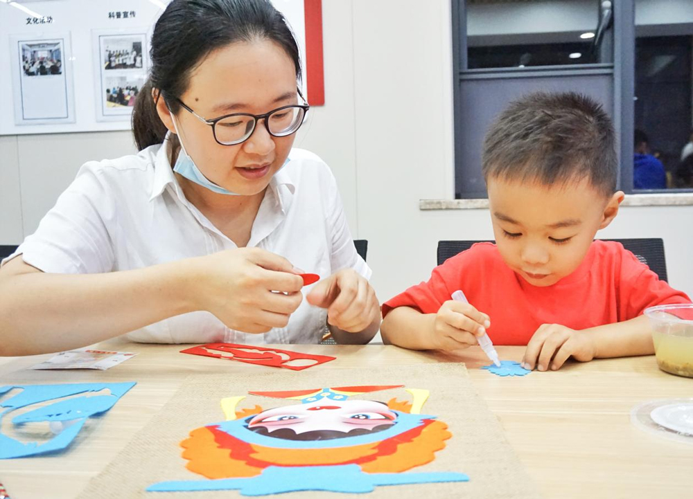 孩子和母亲一起制作京剧脸谱。陶忠德摄