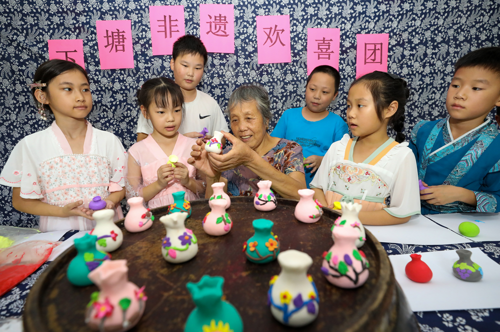 非遗传承人潘百娥手把手教青少年制作非遗欢喜团。白羽摄