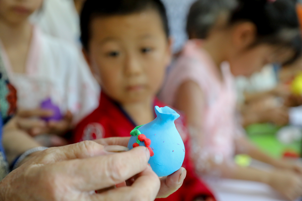 非遗传承人潘百娥手把手教青少年制作非遗欢喜团。白羽摄