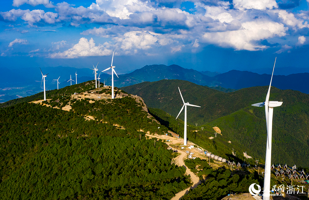 一台台发电机矗立在群山之中，蔚为壮观，成为一道亮丽的风景线。人民网 章勇涛摄