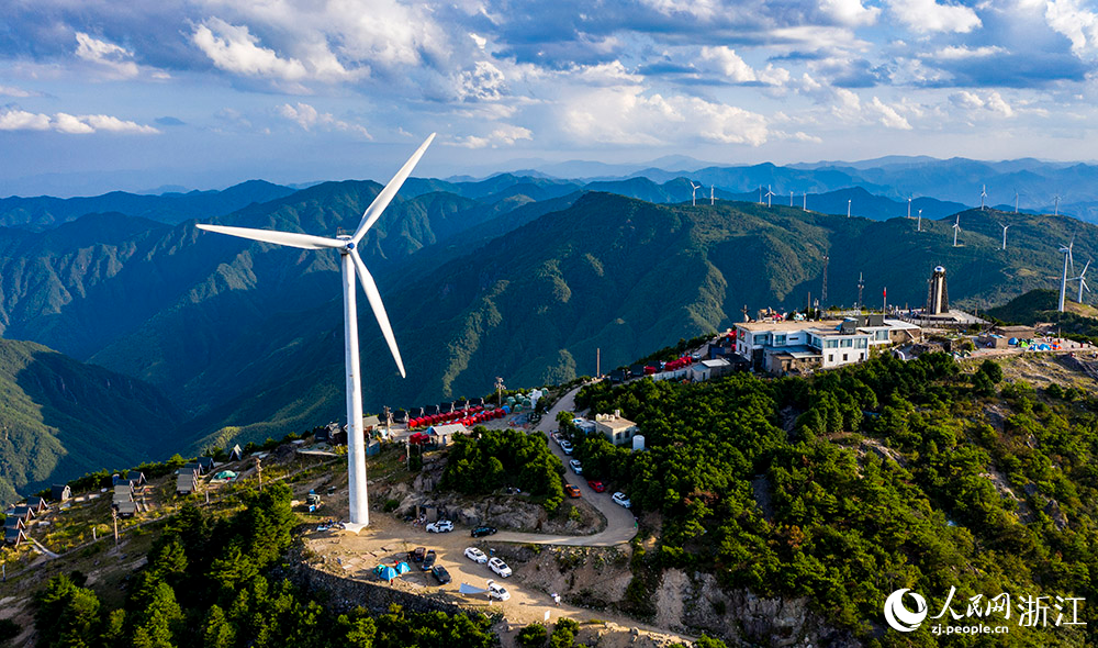 一台台发电机矗立在群山之中，蔚为壮观，成为一道亮丽的风景线。人民网 章勇涛摄