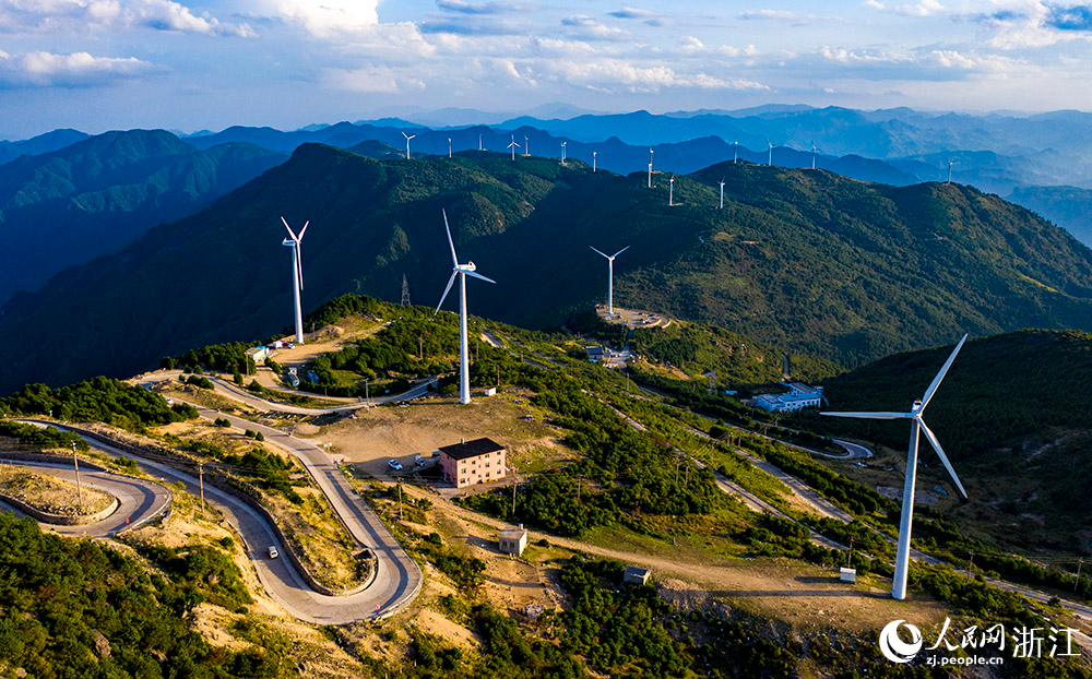 一台台发电机矗立在群山之中，蔚为壮观，成为一道亮丽的风景线。人民网 章勇涛摄