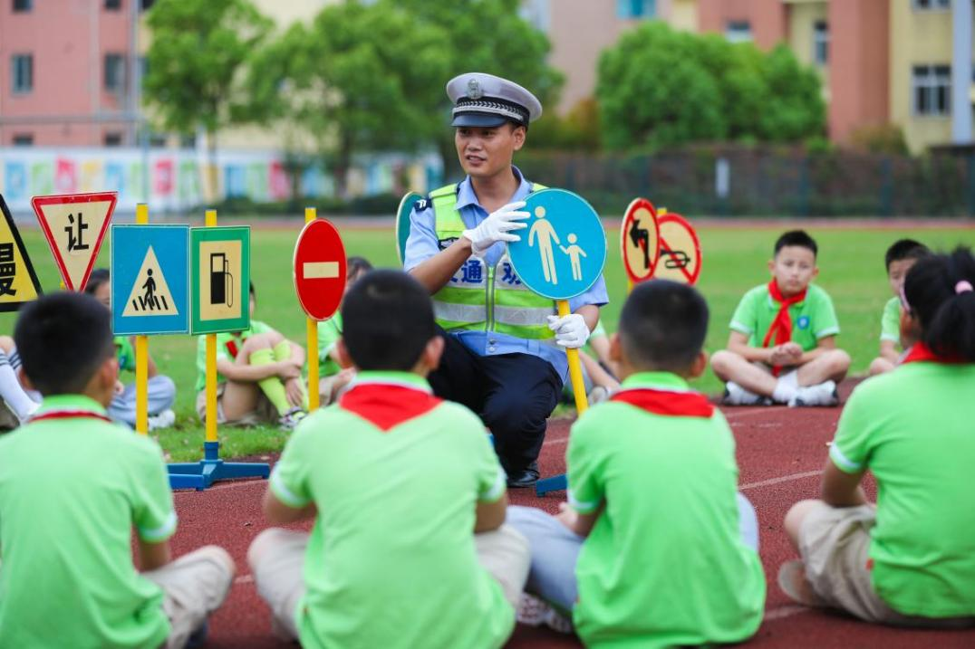 交警给学生们讲解交通安全标识。王正摄