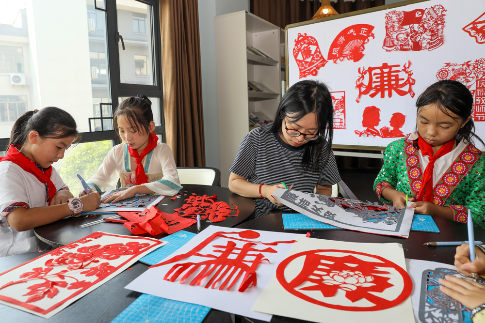 湖州市德清县钟管镇一所小学组织师生共同创作“尊师重教，廉洁从教”非遗剪纸作品。白羽摄