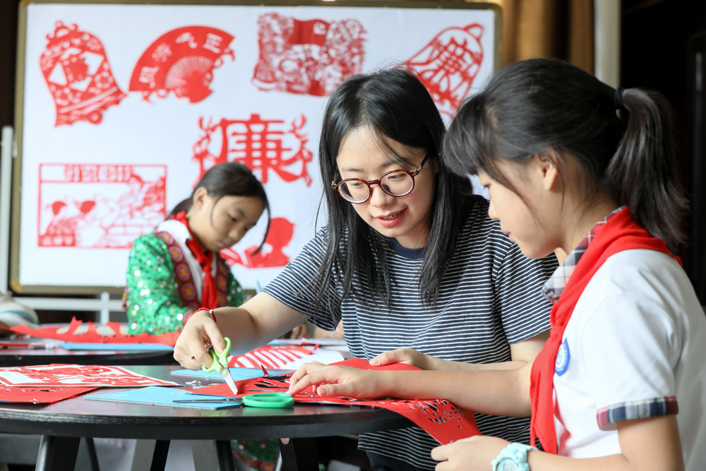 湖州市德清县钟管镇一所小学组织师生共同创作“尊师重教，廉洁从教”非遗剪纸作品。白羽摄