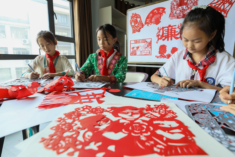 湖州市德清县钟管镇一所小学组织师生共同创作“尊师重教，廉洁从教”非遗剪纸作品。白羽摄