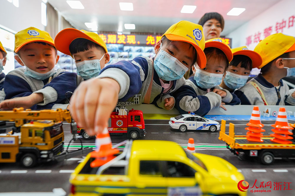 小朋友们在高速公路沙盘模型前辨识常见交通标志。人民网 章勇涛摄