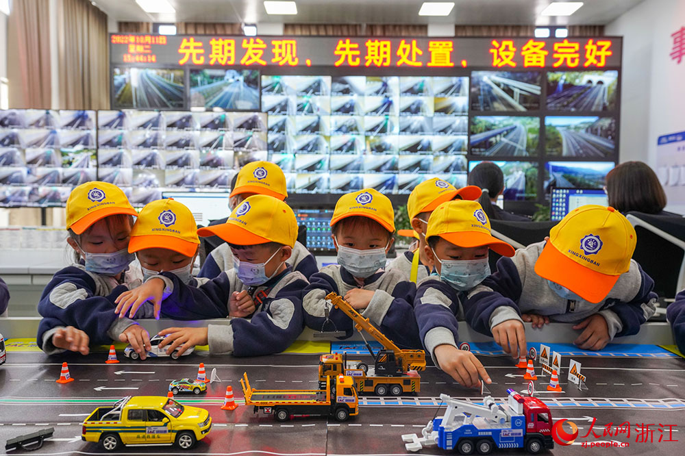 小朋友们在高速公路沙盘模型前辨识常见交通标志。人民网 章勇涛摄