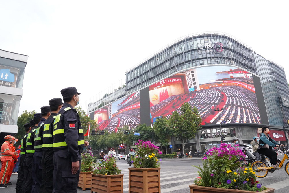 在杭州市上城区湖滨步行街，安保及城管队员一同观看党的二十大开幕会直播。湖滨街道供图