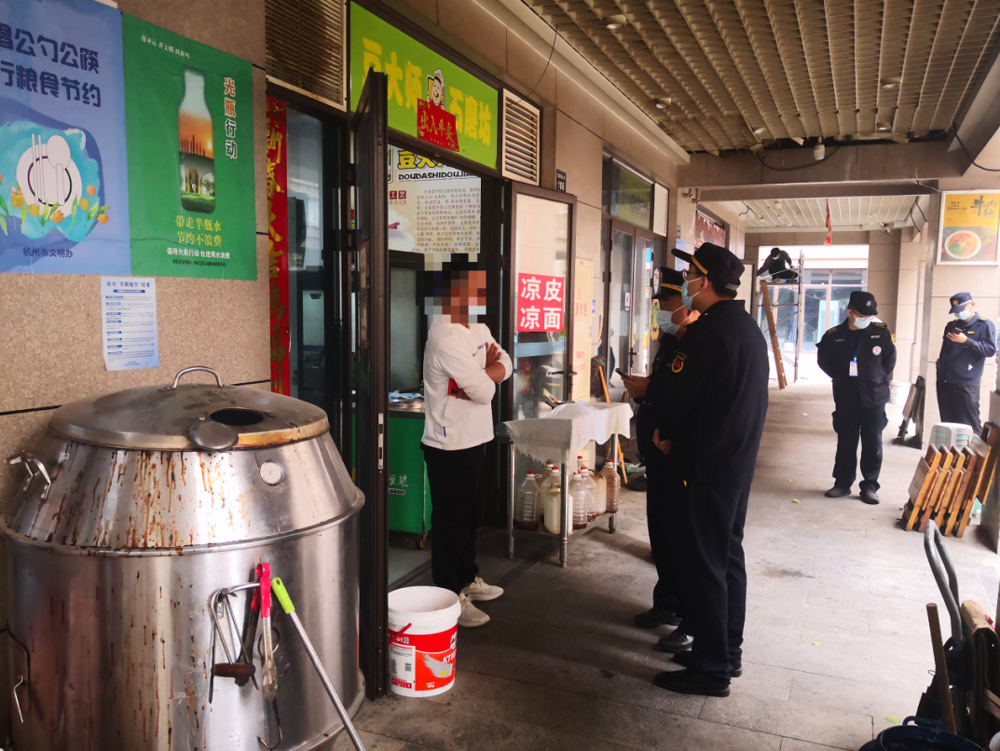 近日，余杭区闲林街道综合行政执法队对一餐饮商铺经营者未将其他垃圾投放至其他垃圾收集容器内的行为开具电子罚单。余杭区综合行政执法局供图