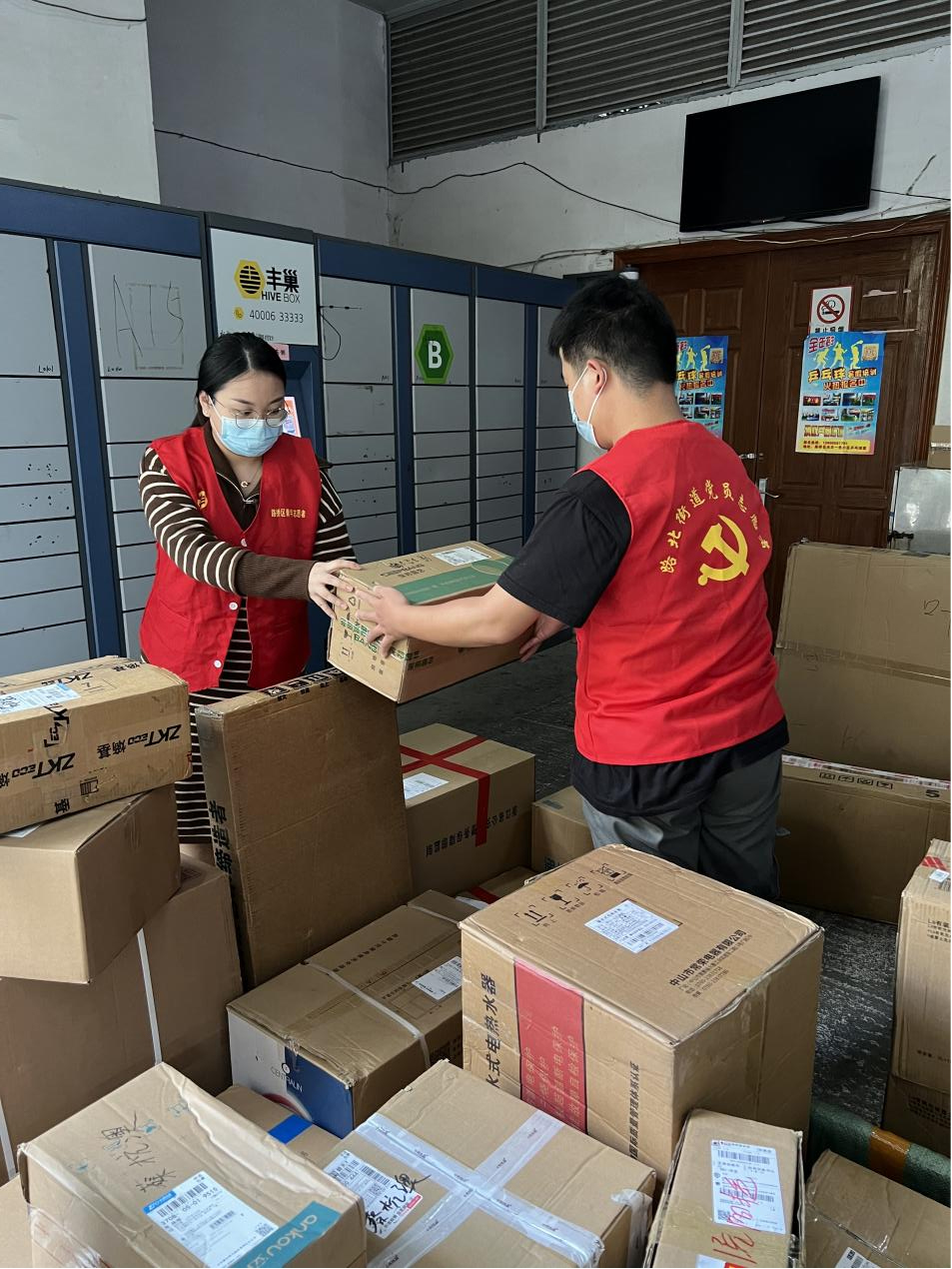 党员志愿者帮助快递小哥一起搬卸、分拣货品。蔡邑彬摄