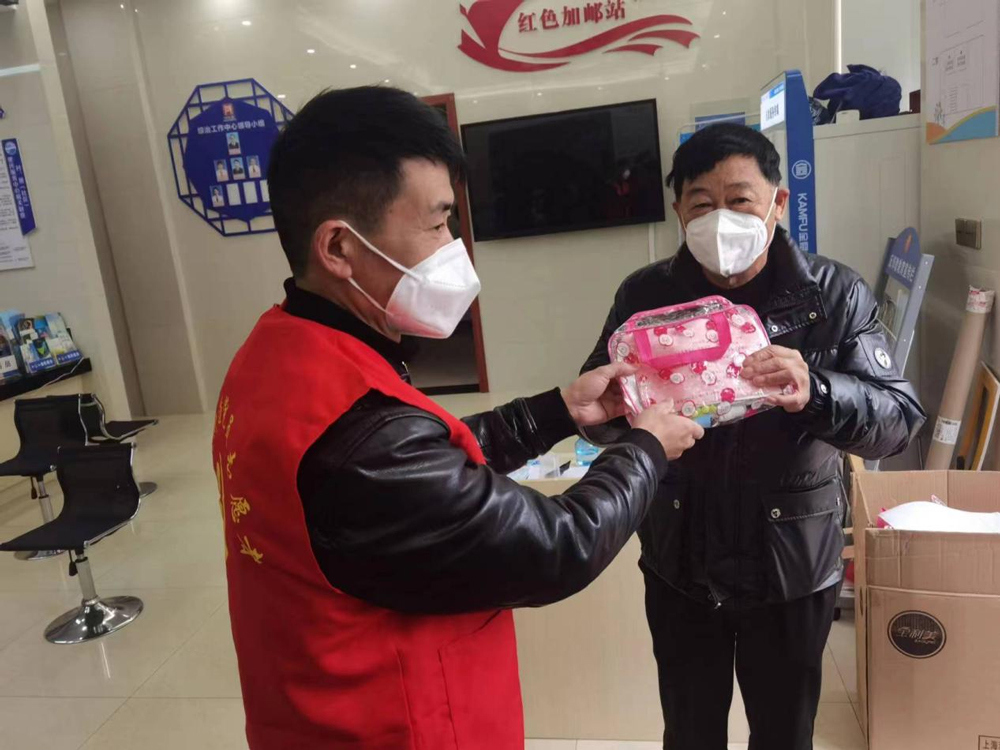 “紅色小分隊”成員將防疫包送到轄區老人手中。李美嬌攝