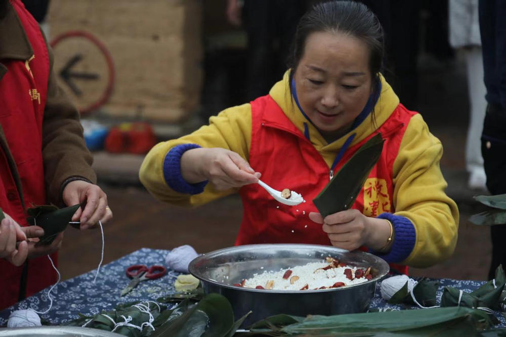 宁海县梅林街道河洪村文化礼堂，志愿者正在包粽子。宁海县委宣传部供图