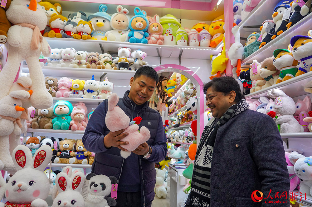 2月2日，在义乌国际商贸城，印度客商Raja（右一）和市场经营户在洽谈。人民网 章勇涛摄