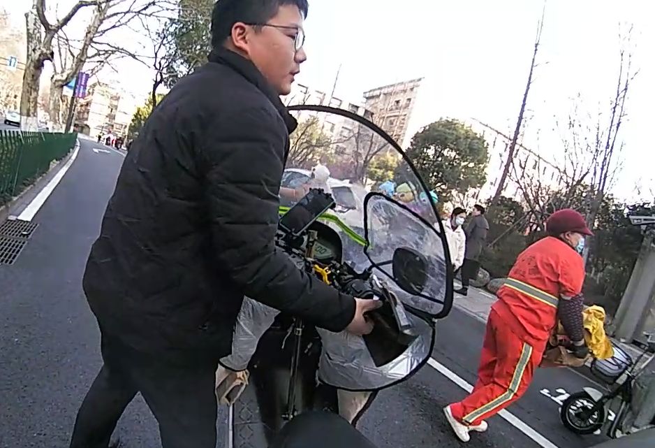 路过市民帮忙挪车。外卖小哥不慎摔倒。杭州市公安局交警支队供图