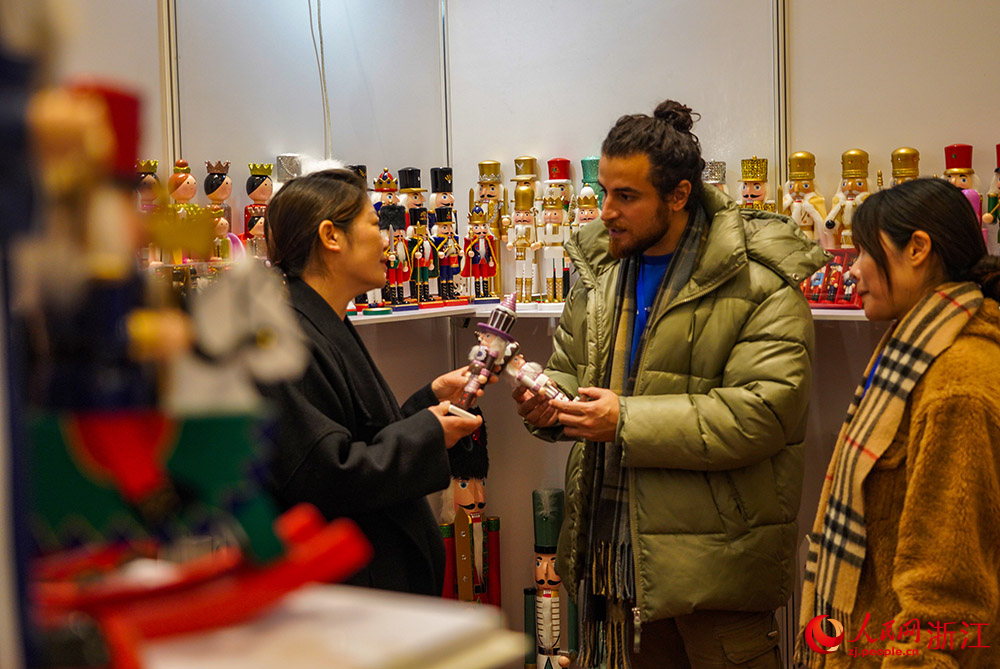 2月24日，在台州市黄岩区，来自伊朗的外商毕泽德（中）在了解一款产品胡桃夹子。人民网  章勇涛摄