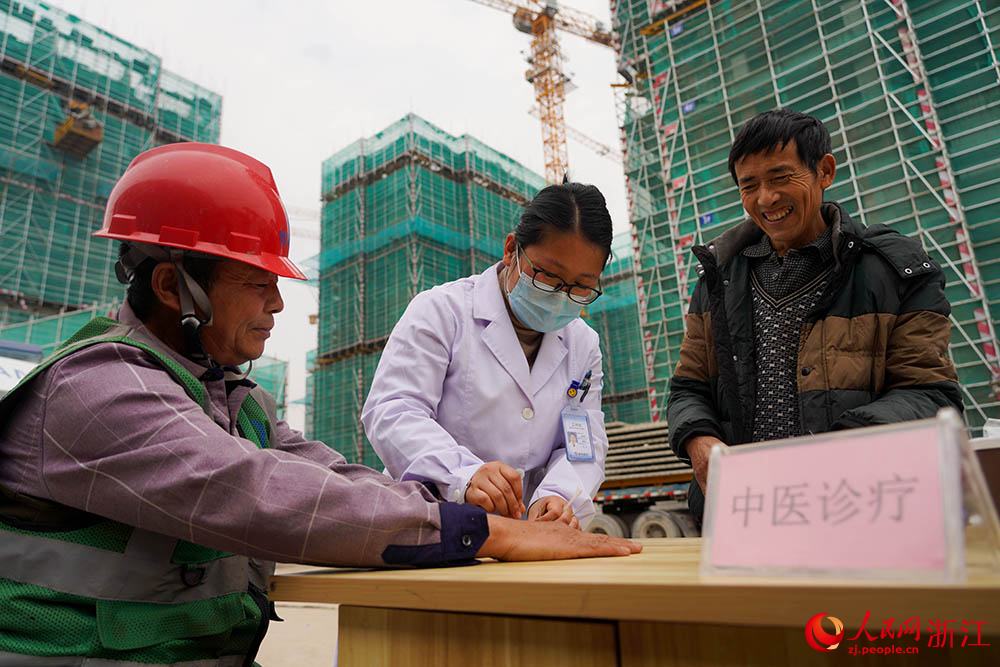 3月1日，在杭州市拱墅区石桥街道，一名医护志愿者在为工人针灸。人民网 章勇涛摄