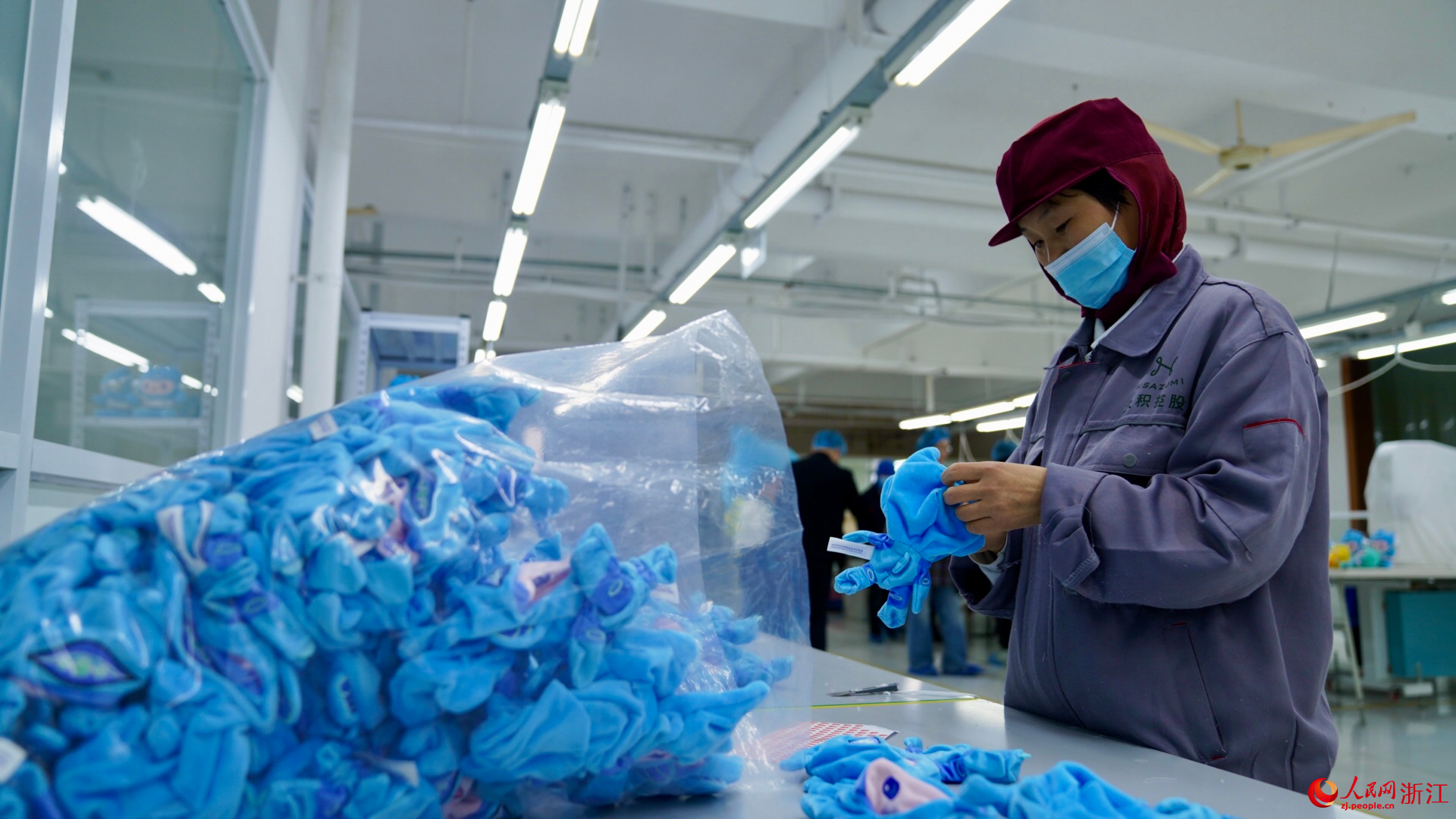 杭州一家亚运会特许生产企业的车间里，工人们正在赶制产品。人民网记者 郭扬摄