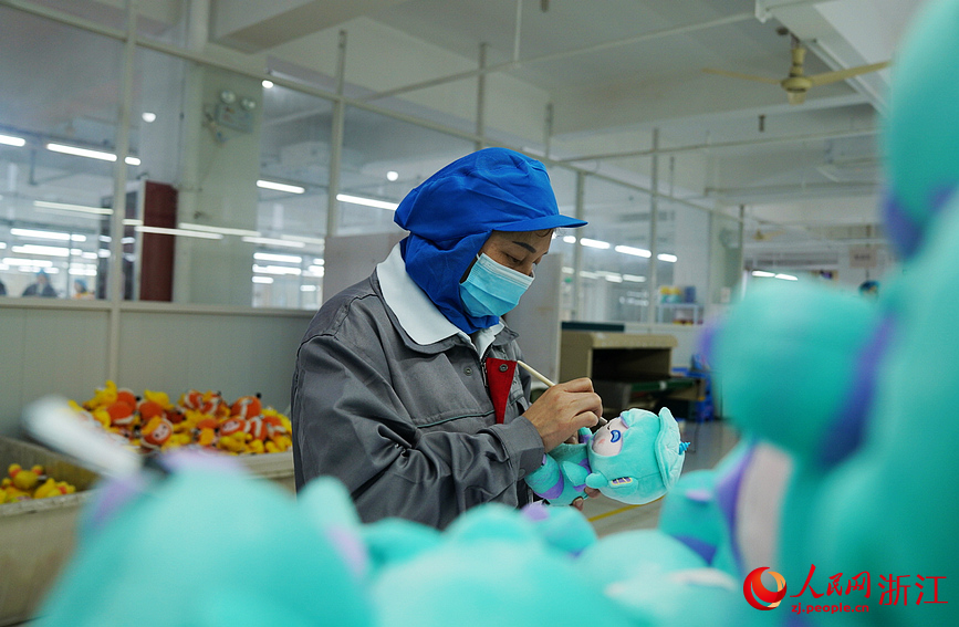 杭州一家亚运会特许生产企业的车间里，工人们正在赶制产品。人民网记者 郭扬摄