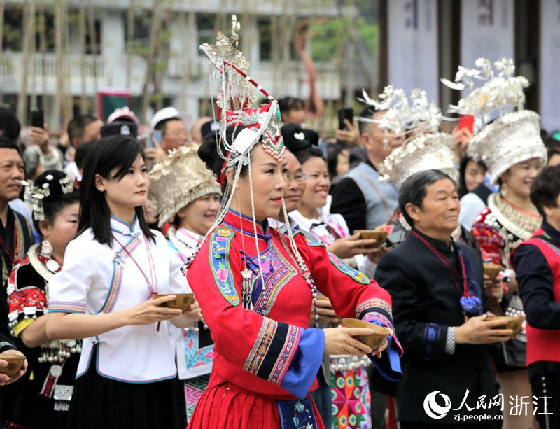 民族同心祈福典礼现场，全场嘉宾手捧茶碗齐唱《祈福歌》。人民网 陈陆洵摄