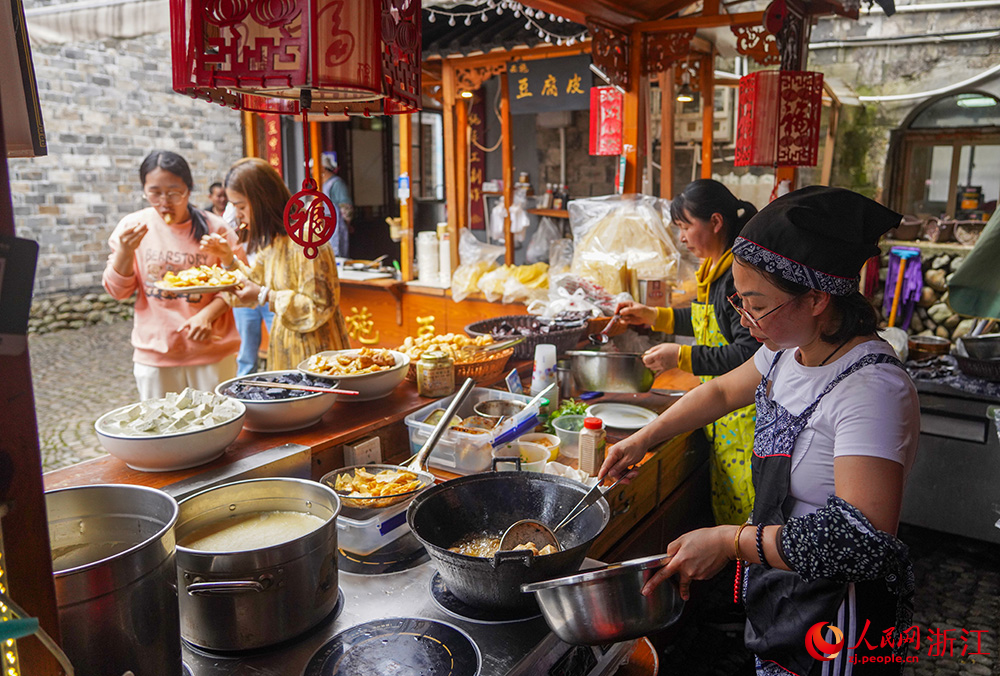 4月28日，游客在宁波市宁海县前童古镇品尝豆制品。人民网 章勇涛摄