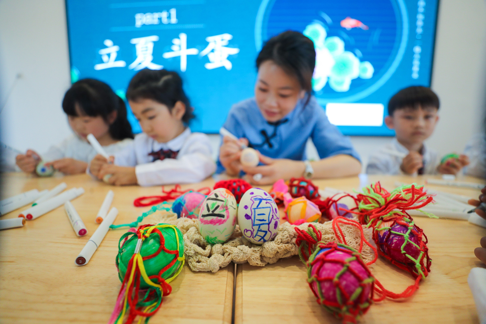 孩子們體驗立夏傳統民俗活動“繪彩蛋”。王正攝