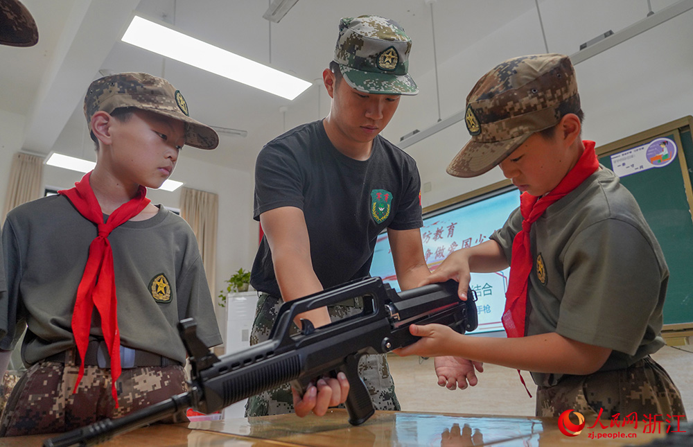 5月15日，在浙江省义乌市北苑小学，学生们在课堂上进行轻武器分解结合比拼。人民网 章勇涛摄